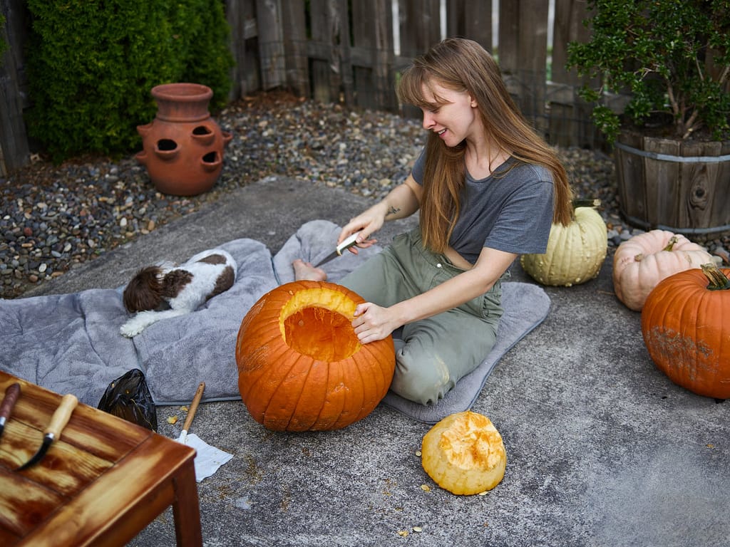 a woman carving a pumpkin decorations