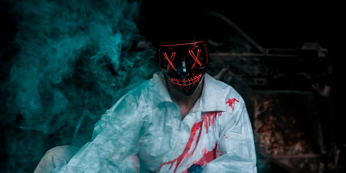 man wearing a black mask and bloody shirt